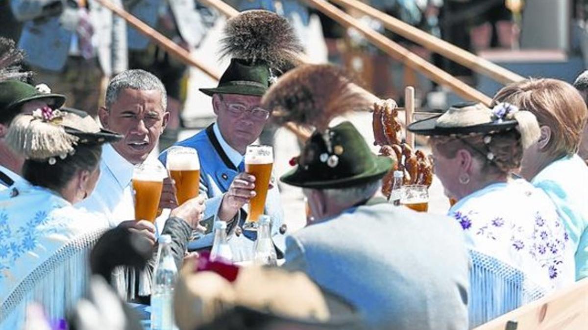 Barack Obama y Angela Merkel comparten una cerveza bávara en un ambiente distendido, ayer.