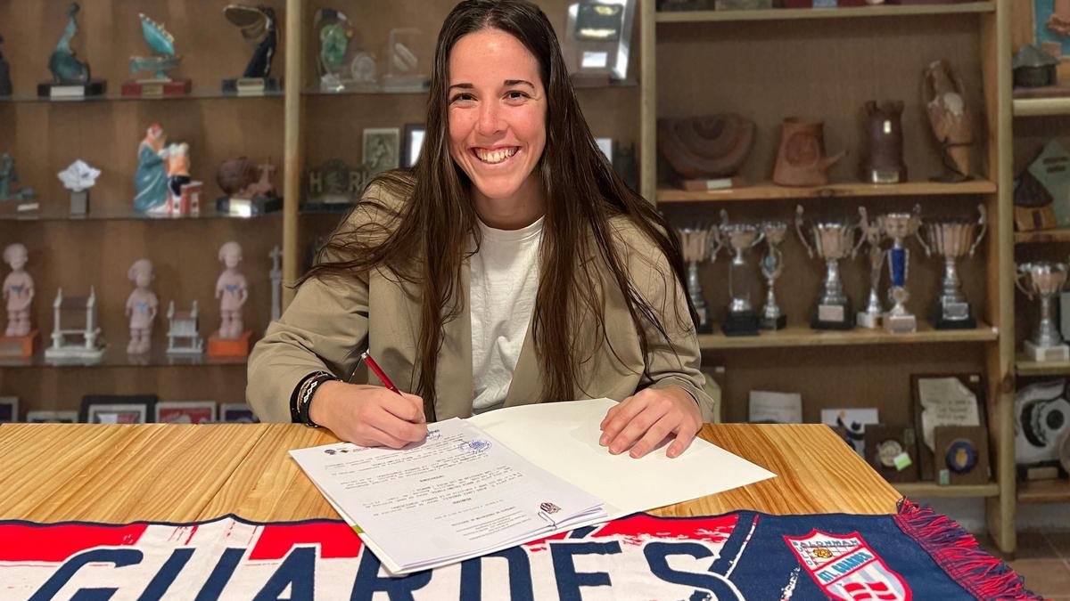 María Palomo firma su nuevo contrato en la sala de trofeos.