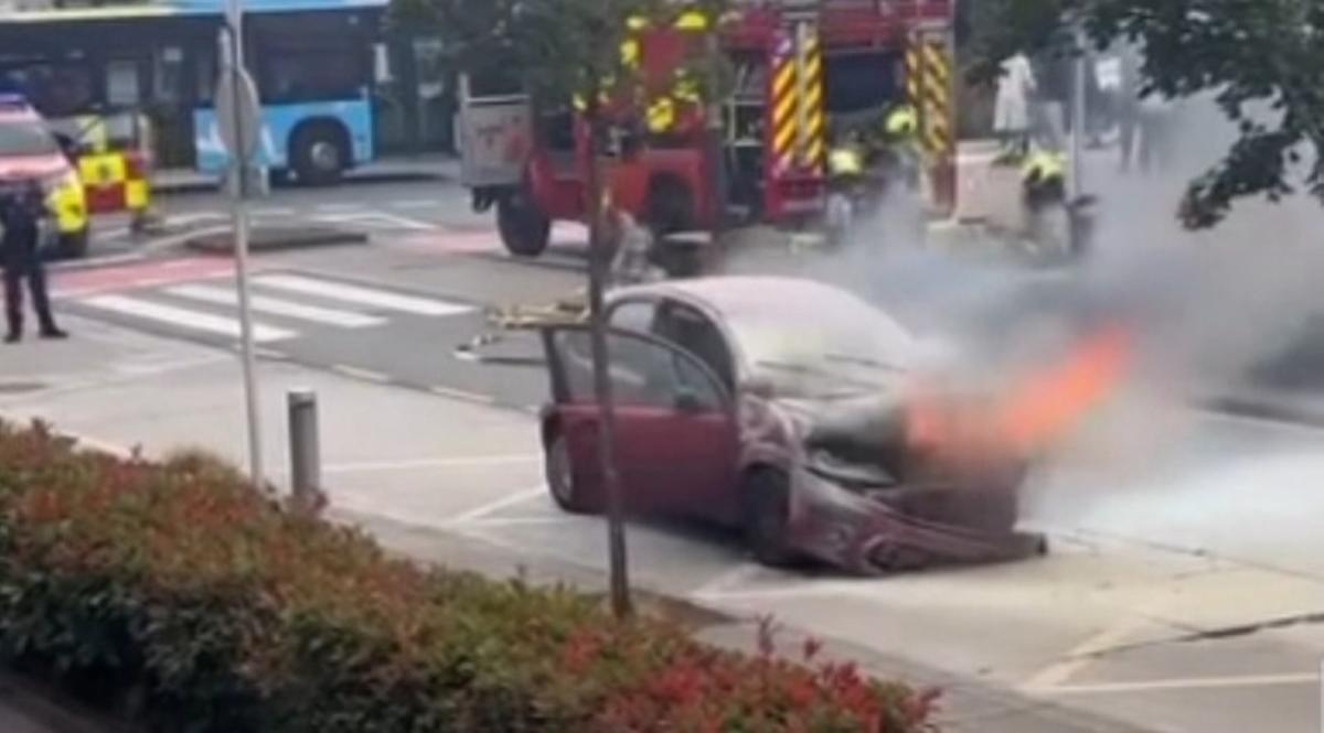 Un instante de la intervención de los Bomberos de Santiago para sofocar las llamas del coche incendiado en el barrio de Fontiñas este lunes