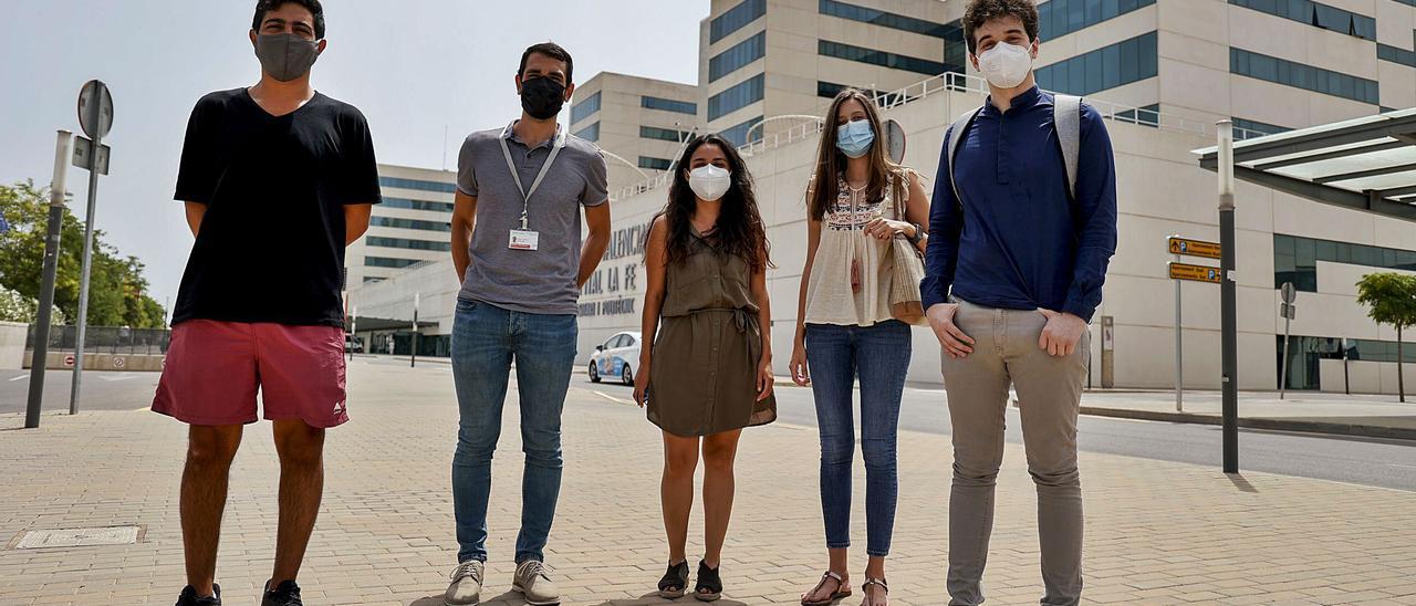 Los cinco residentes de La Fe en Intensiva y Preventiva (Ilan Cultrera, Juan Juaneda, Gema Vignoly, Ángela Poquet y Javier de Ancos) posan frente al hospital.  | FERNANDO BUSTAMANTE