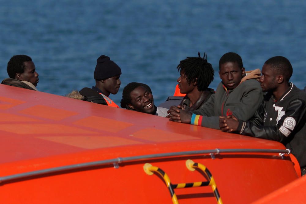 Migrants stand on a rescue boat upon arriving at ...