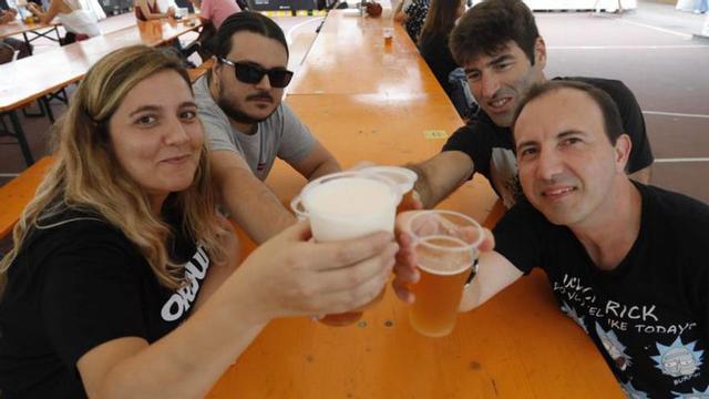 1. De izquierda a derecha, María Silva, David Sánchez, José Manuel Fernández y Ramón Fernández brindan en una de las mesas. 2. Inés Escandón sirve una caña en su puesto. 3. De izquierda a derecha, Pablo García, Inés Dinten, Luis Lus y Nica García brindan en su stand. 4. El equipo de La Braña, con los fogones en marcha preparado para afrontar la primera jornada de festival. 5. El centro de la pista de La Exposición, con gente sentada en las mesas disfrutando de su cerveza. | |  RICARDO SOLÍS