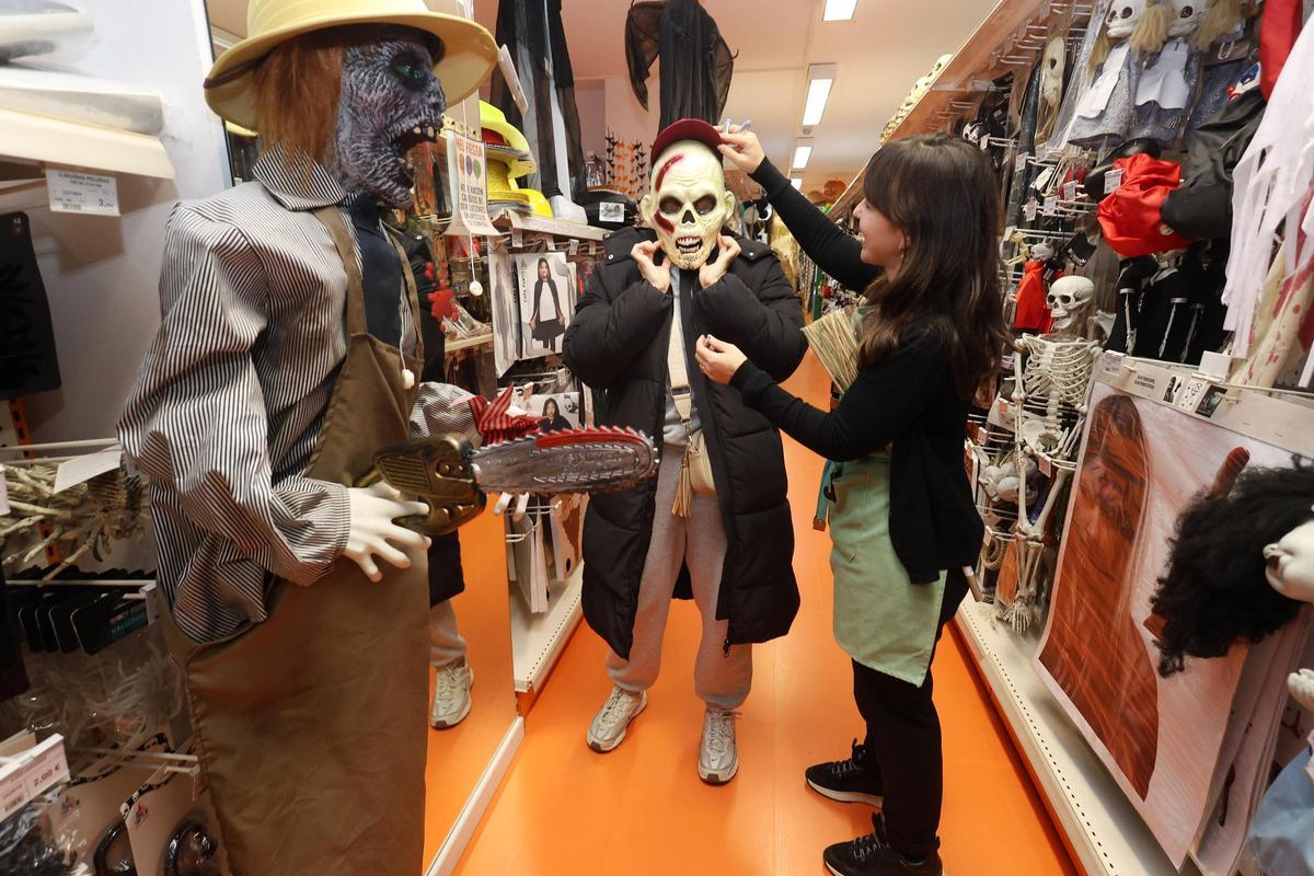 Melisa, de MeliFiesta, ayuda a una clienta a probarse una máscara.