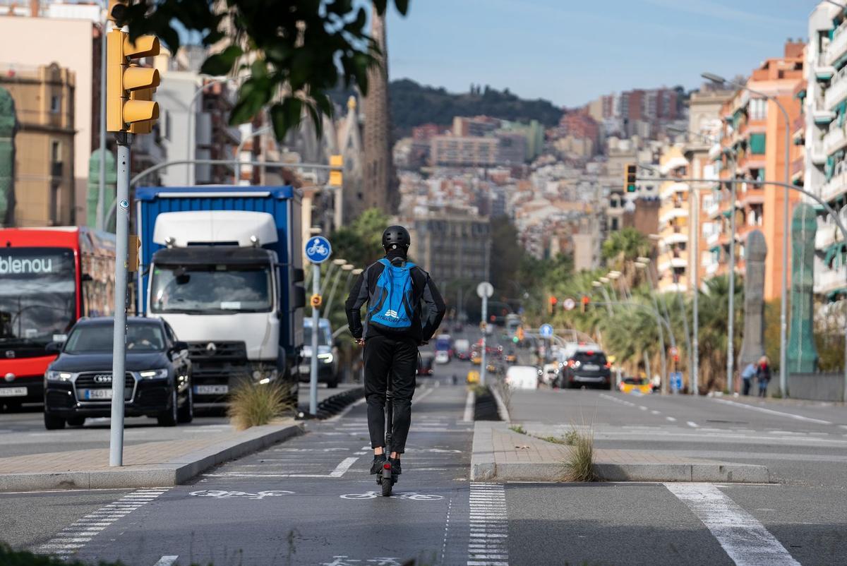 Persona sobre un patinet elèctric circulant pel carril bici