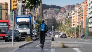 Persona sobre un patinet elèctric circulant pel carril bici
