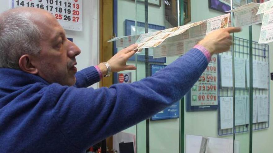 Jesús Gutiérrez coloca los billetes para el sorteo del Niño en Luarca.