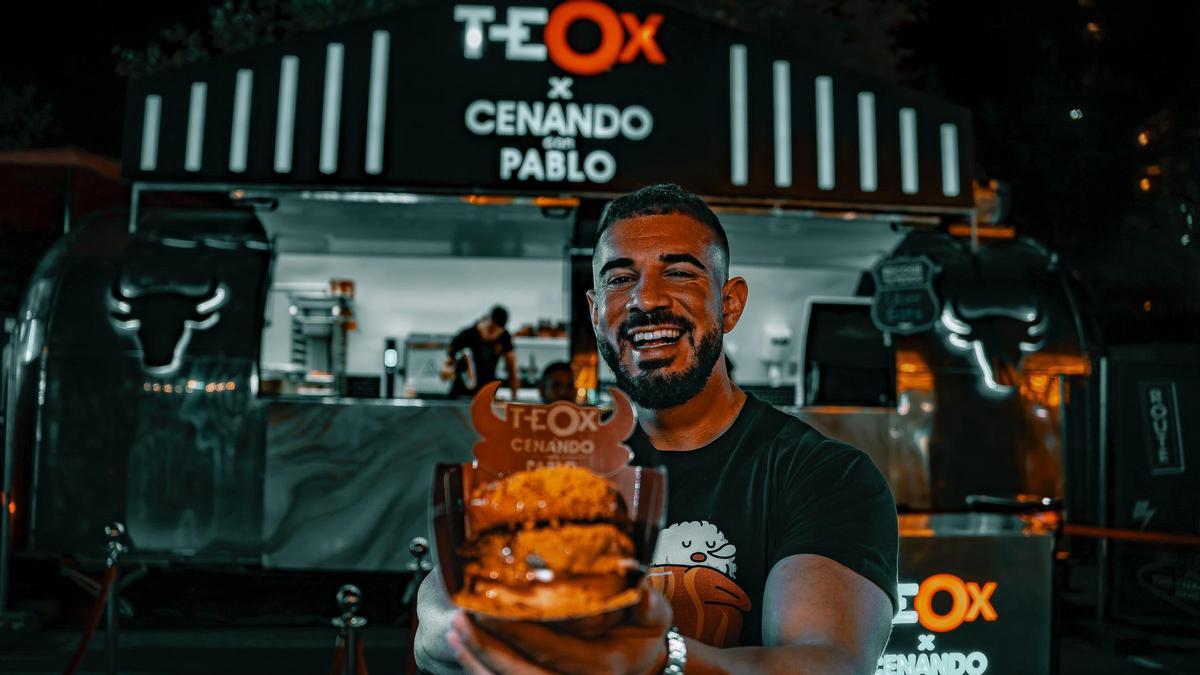 El influencer Pablo Cabezali, conocido en redes como Cenando con Pablo, pasando con su hamburguesa en una edición de la Champions Burger