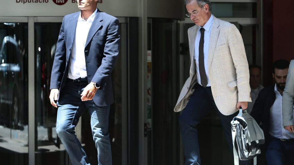 Joaquín Aguirre (derecha) sale de un edificio de la Diputación de Barcelona, después de un registro en 2018