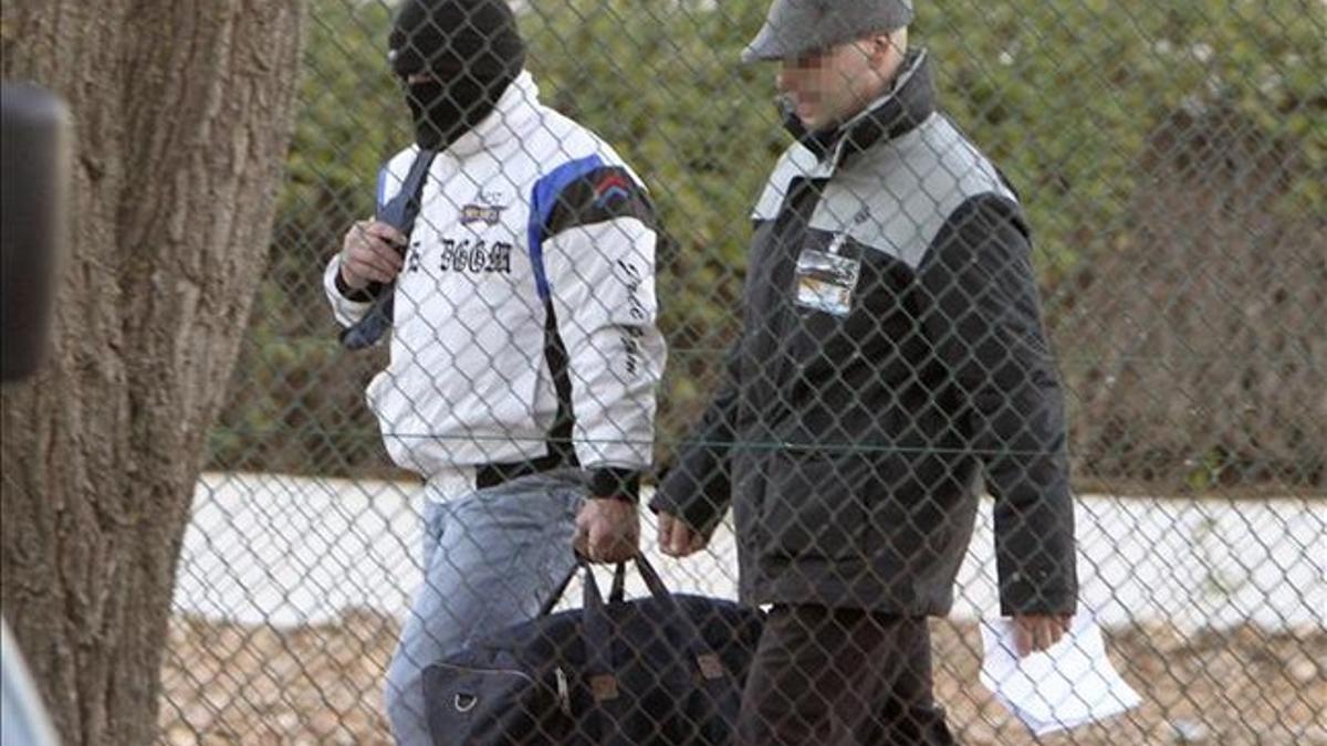 Miguel Ricart, con el rostro oculto, a su salida de la cárcel junto a un guardia civil.