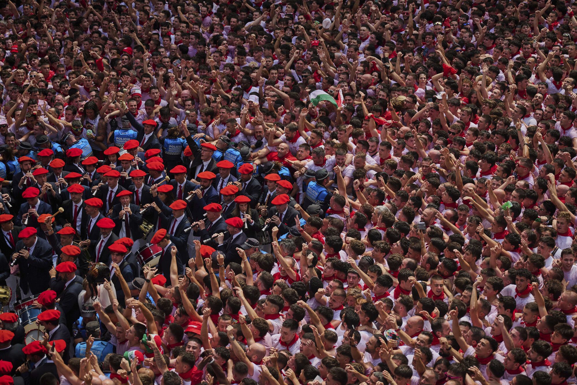 A municipal music band makes it's way through the crowd as revelers pack the main square during the start of nine days of uninterrupted partying in Pamplona's famed running-of-the-bulls festival in Pamplona, Spain, Sunday, July 6, 2025. (AP Photo/Miguel Oses). EDITORIAL USE ONLY/ONLY ITALY AND SPAIN