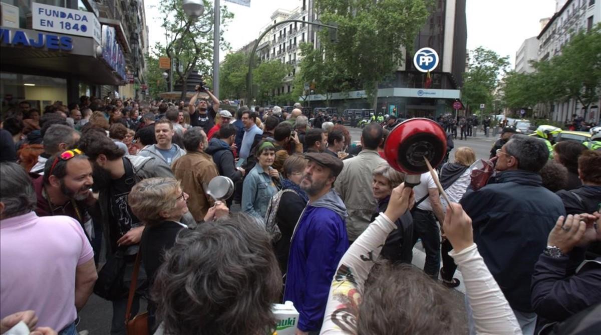 Participantes en la cacerolada de protesta contra los casos de corrupción en el PP, ante la sede del partido, en la madrileña calle Génova.