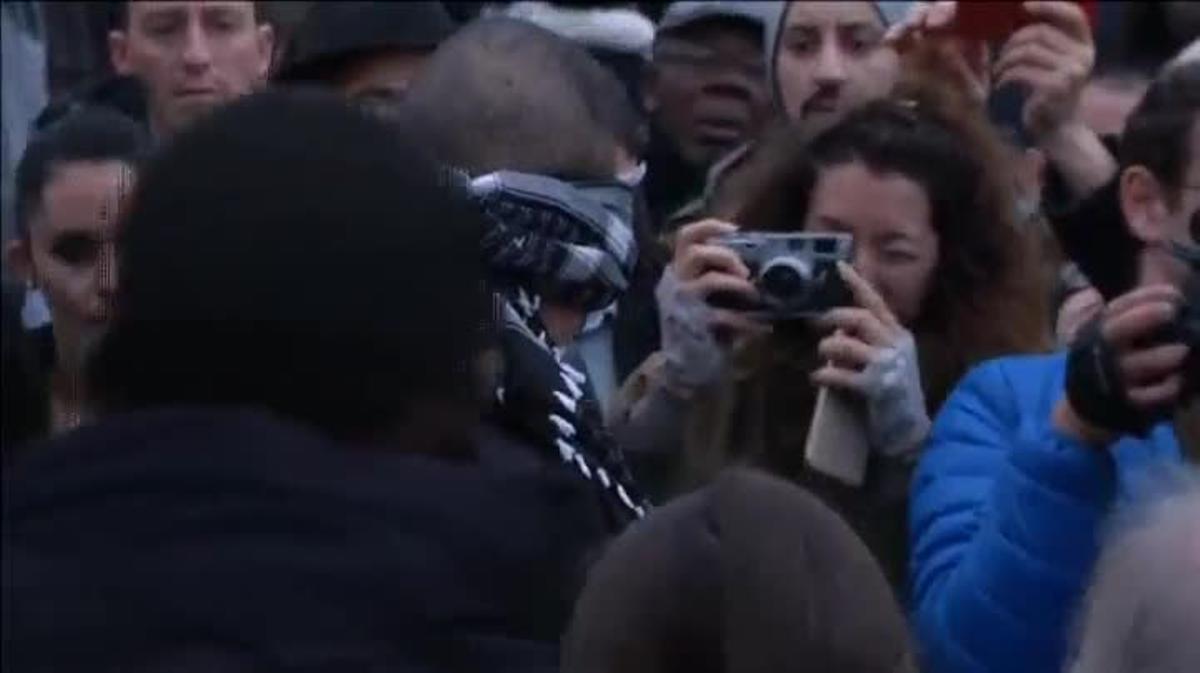 Un jove musulmà, amb un mocador lligat al cap, demana confiança i abraçades en plena Plaça de la República de París.