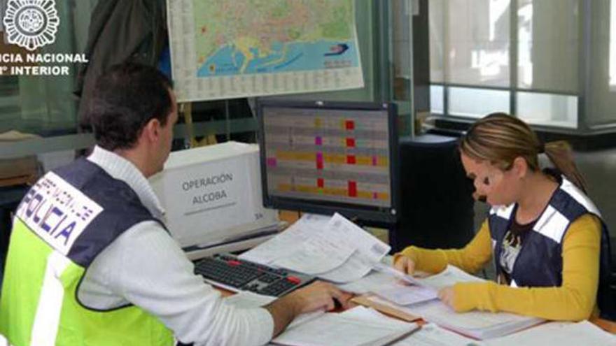 Dos agentes examinan documentos del caso.