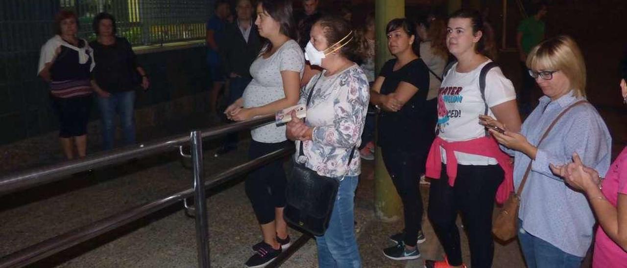 Madres esperan a los niños a la entrada del colegio Alejandro Casona de Cangas del Narcea.