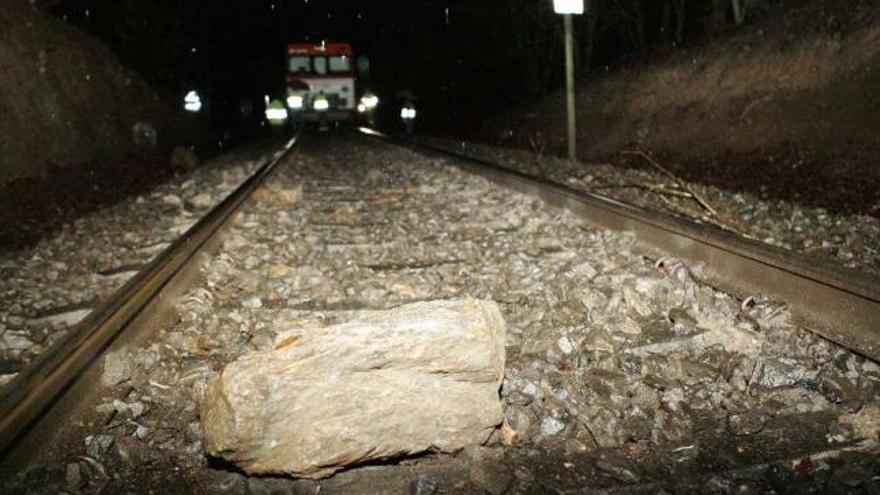 Una de las piedras que provocó el descarrilamiento de la máquina del tren, al fondo.  // Bernabé/Gutier