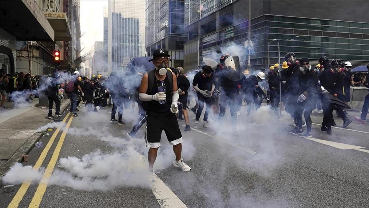 Manifestantes frente a los gases lacrimógenos lanzados por la policía en Hong Kong.