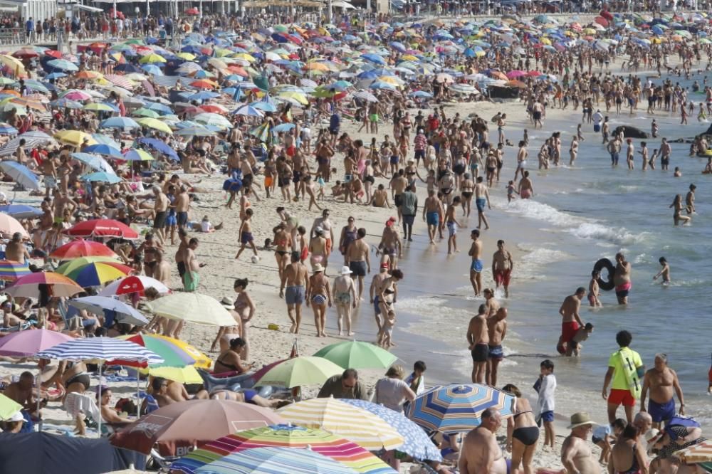 El buen tiempo anima a los bañistas en la playa de Samil