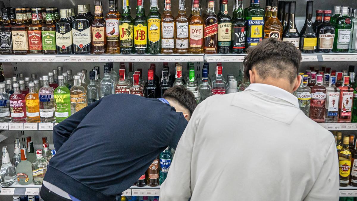 Dos jóvenes compran alcohol en un supermercado cercano a la plaza de Catalunya de Barcelona, en mayo pasado.