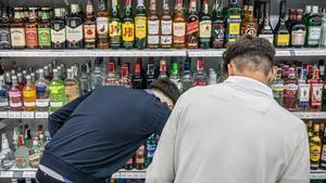 Dos jóvenes compran alcohol en un supermercado cercano a la plaza de Catalunya de Barcelona, en mayo pasado.