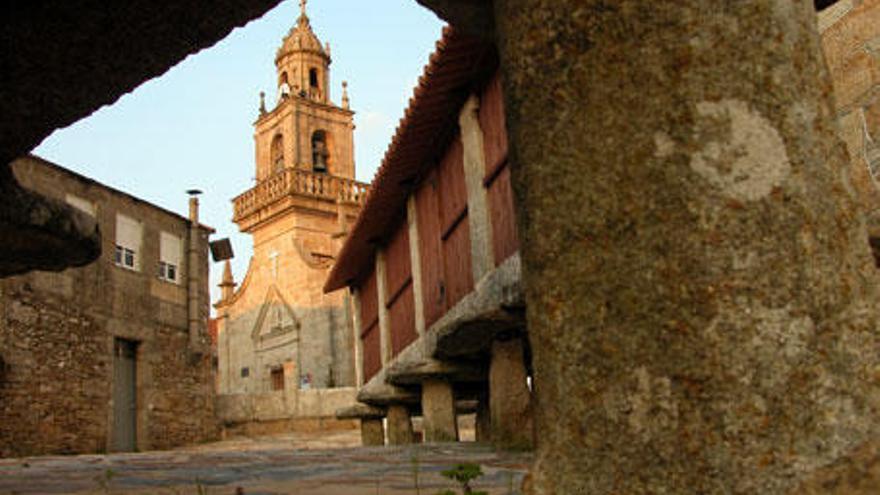 Vista de la plaza -con hórreo- en la que se alza la iglesia de Santa María.