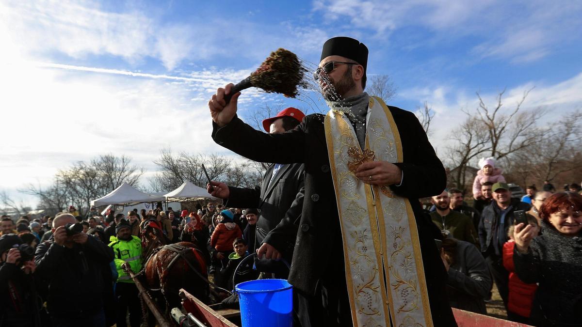 Un cura rumano ortodoxo bendice a los asistentes a una misa.