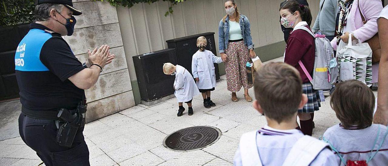 El subinspector Bernardo González da instrucciones a niños y padres a la entrada del colegio de las Dominicas, en Oviedo.