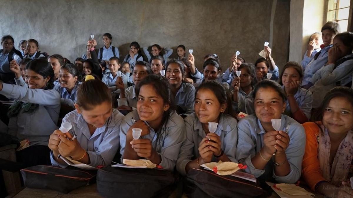 Unas jóvenes nepalís inspUnas jóvenes inspeccionan las copas menstruales en la ciudad nepalí de Kalagaun. eccionan las copas menstruales en la ciudad nepalí de Kalagaun.