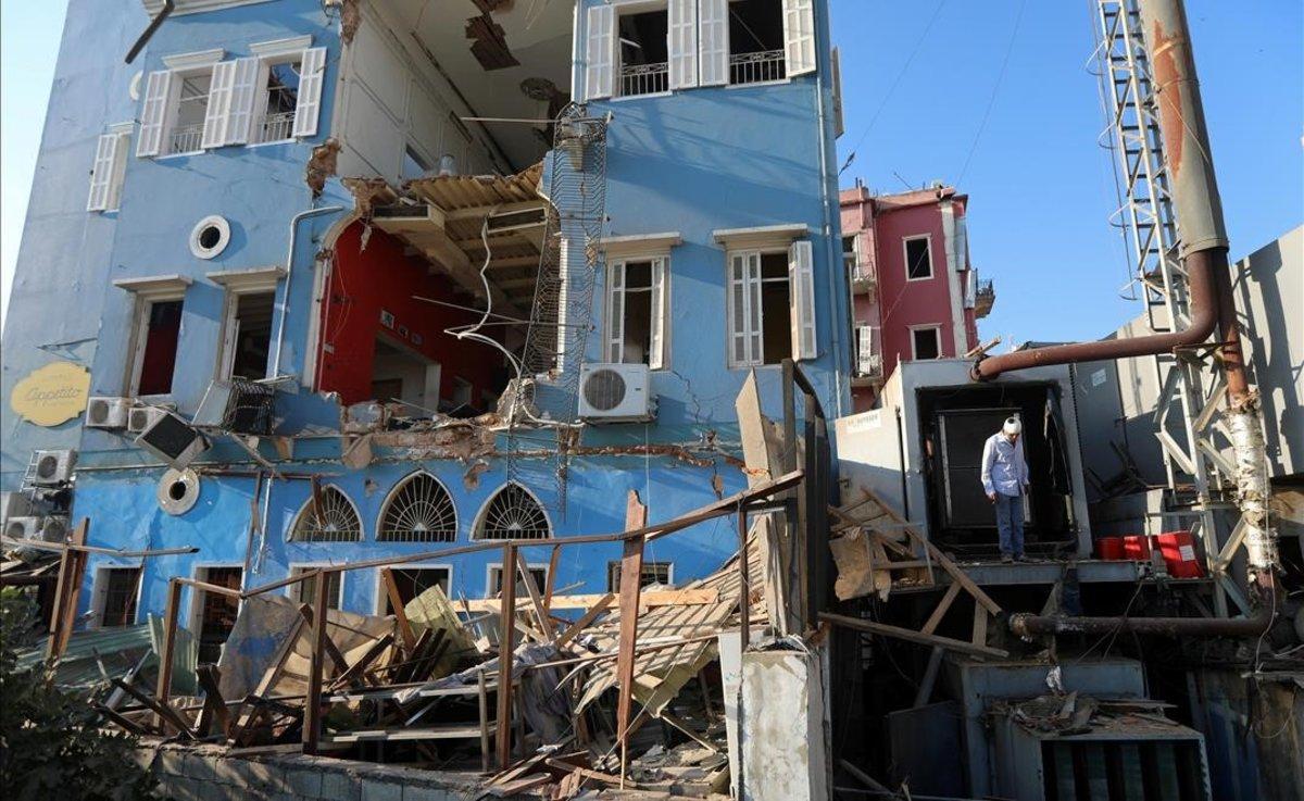 Un hombre evalúa los daños en un edificio afectado por la explosión.