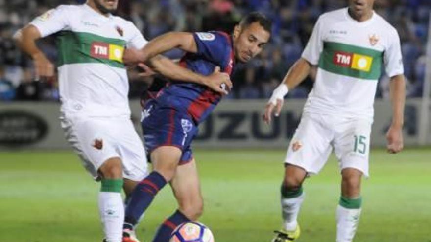 Correa lucha por un balón en la medular, con un jugador del Huesca, con su compañero Pedro al lado.