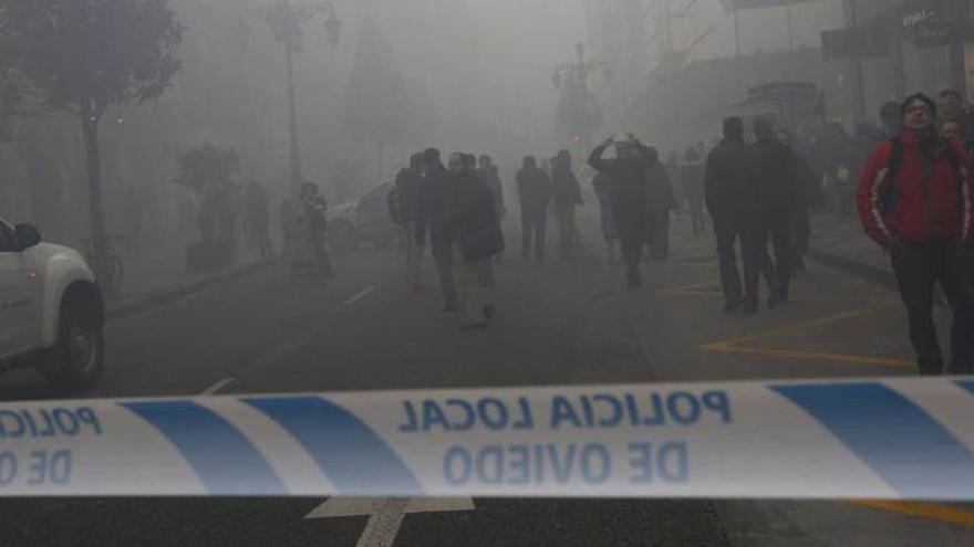 Varios vecinos de Oviedo sacan fotos y pasean por la calle Uría durante las primeras horas del incendio ocurrido ayer en la ciudad.