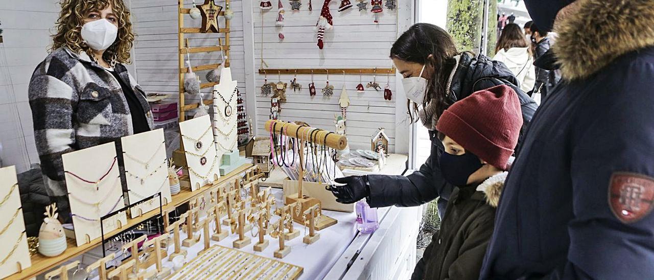 Andrés Jáñez y Noelia Suárez, con su hijo Miguel, comprando en el puesto de Noemí Suárez. | Julián Rus