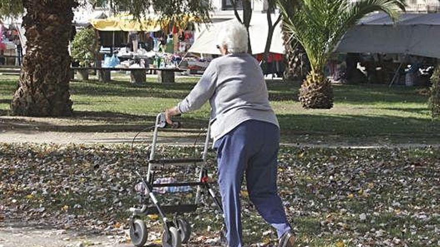 Una mujer de edad avanzada camina apoyada en un andador.