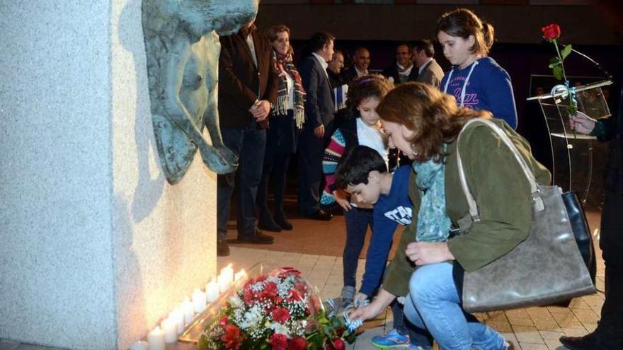 Un grupo de niños deposita flores ante el monumento en honor a los fusilados el 12 de noviembre. // R. V.