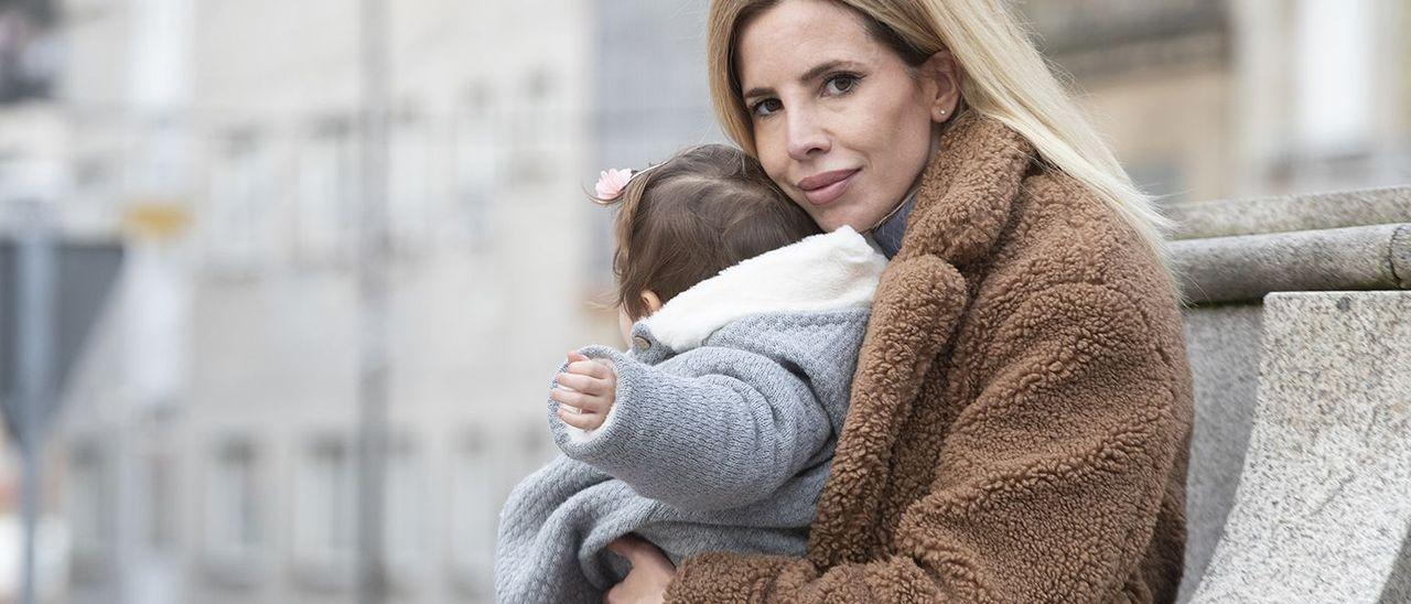 Tamara Domínguez, junto a su hija de 14 meses en la plaza del Mercado de Teis.