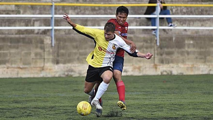 Eric Santmartí, autor del primer gol del partit, protegeix la pilota davant del defensor de la Torreta