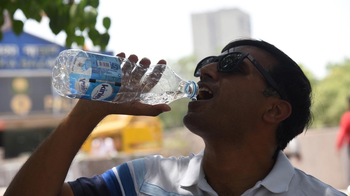 Un hombre bebe agua durante una ola de calor
