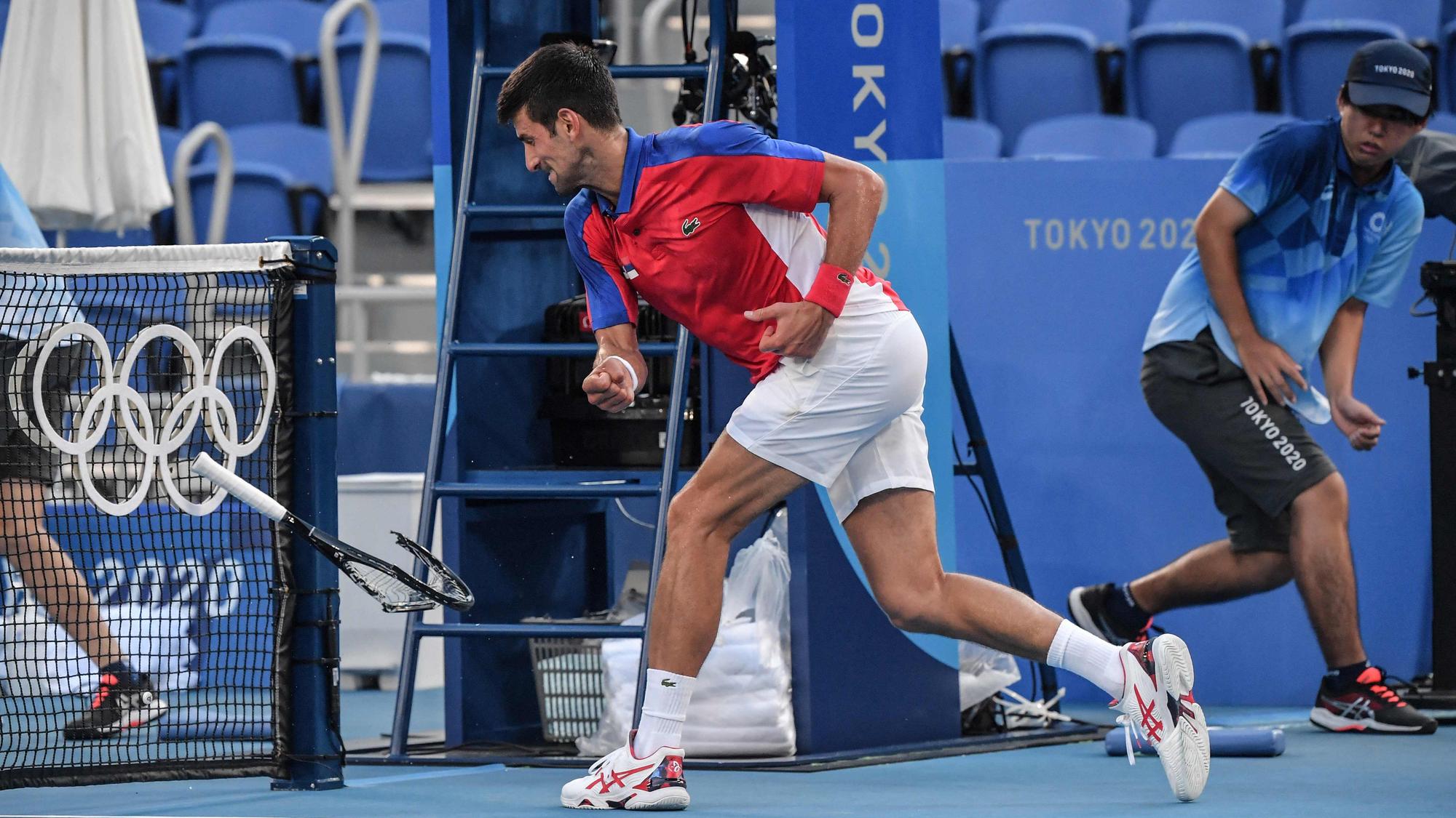 Serbia's Novak Djokovic smashes his racket during his Tokyo 2020 Olympic Games men's singles tennis match for the bronze medal against Spain's Pablo Carreno Busta at the Ariake Tennis Park in Tokyo on July 31, 2021. (Photo by Tiziana FABI / AFP)