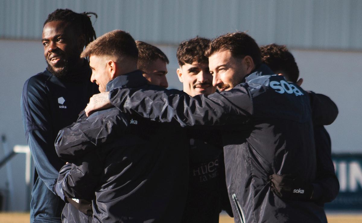 Varios jugadores de la SD Huesca forman un corro durante un entrenamiento.