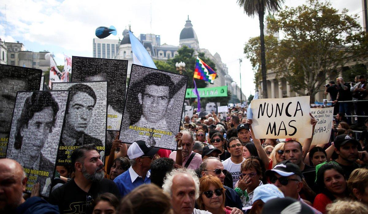 Demonstrators hold images of people who disappeared at the Plaza de Mayo square to commemorate the 43rd anniversary of the 1976 military coup  in Buenos Aires  Argentina March 24  2019  The banner reads   Never again   REUTERS Agustin Marcarian
