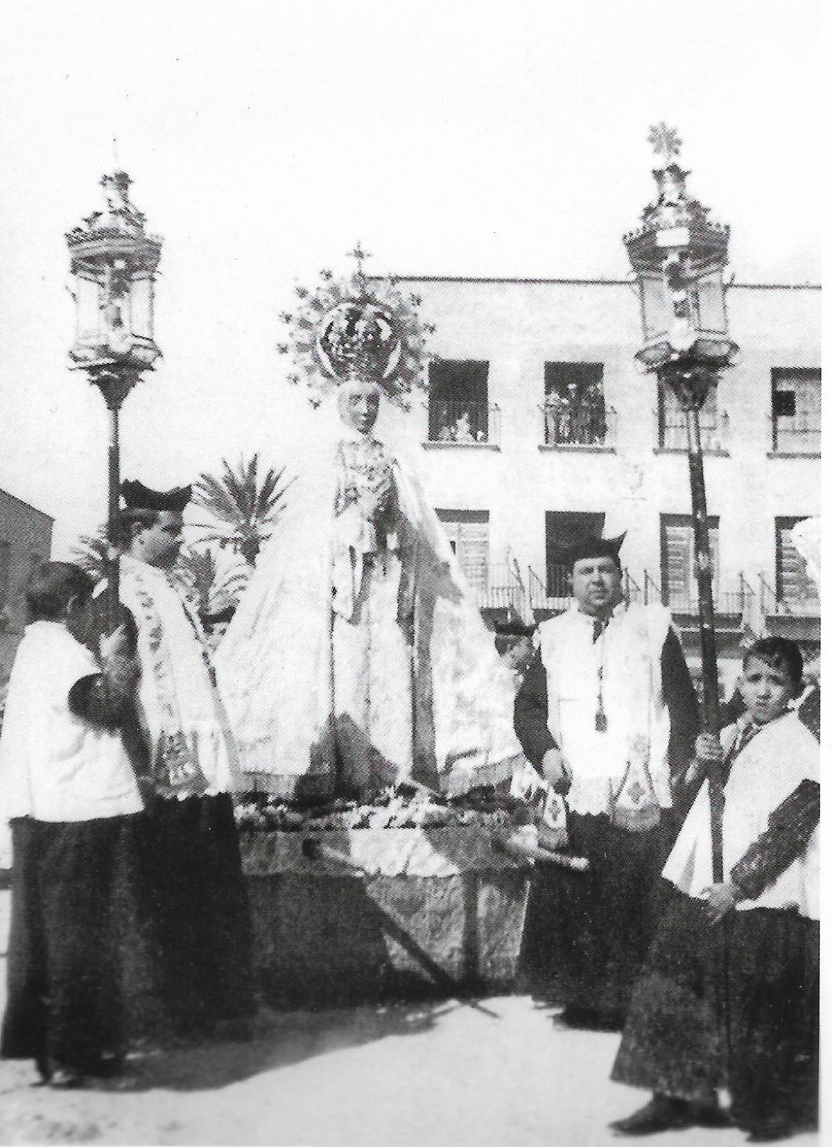 La Virgen de pie en las andas portadas por sacerdotes (1903).