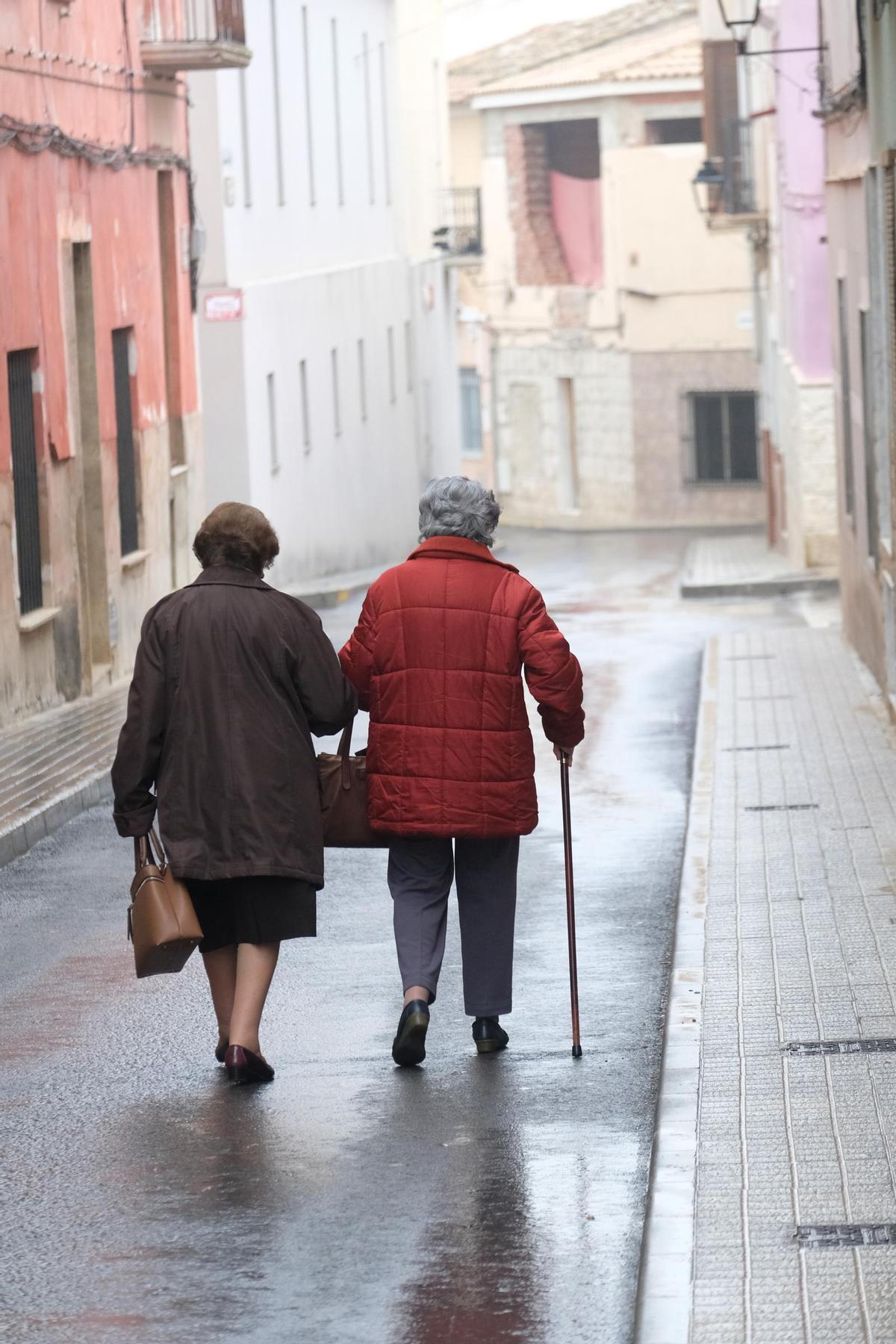 Dos mujeres mayores caminan por la calle.