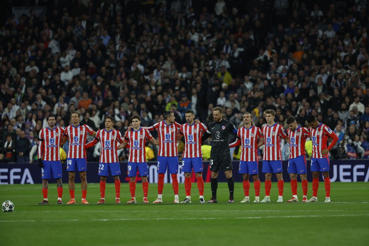 Los jugadores del Atlético de Madrid guardan un minuto de silencio por Javier Dorado, exfutbolista del Real Madrid recientemente fallecido, previo al encuentro correspondiente a la ida de los octavos de final de la Liga de Campeones que Real Madrid y Atlético de Madrid disputan hoy martes en el estadio Santiago Bernabéu, en Madrid.