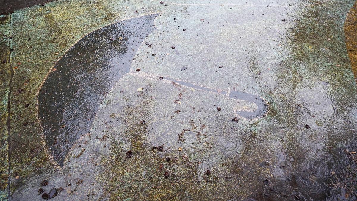 Figura de un paraguas, bajo la lluvia, este domingo en Coia