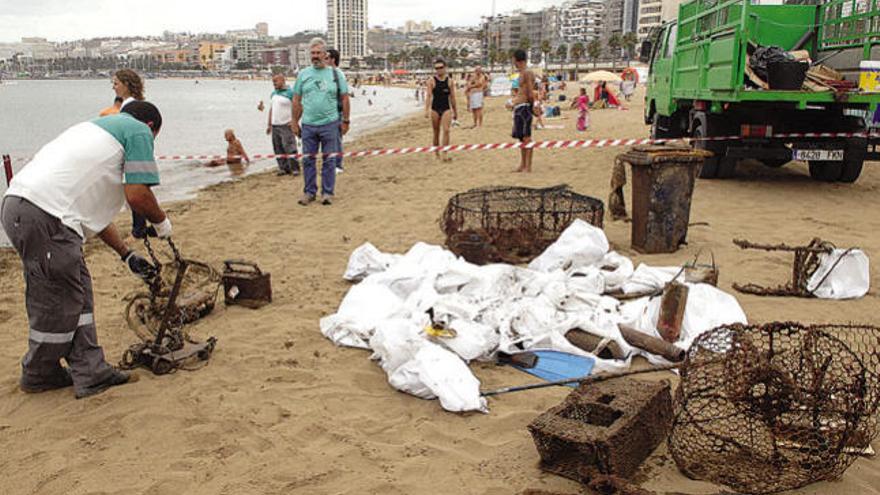 Operarios retiran parte de la basura recogida en el fondo marino de la playa.