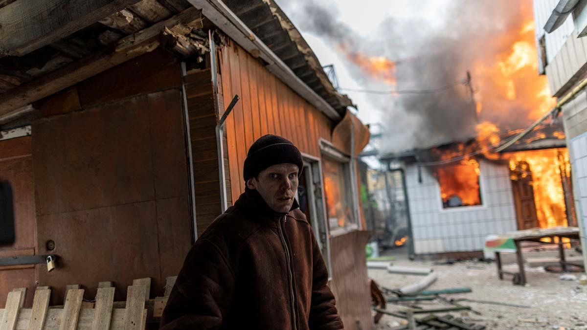 Un ciudadano de Irpin, en Ucrania, se encuentra con una casa ardiendo en la única vía de escape habilitada para dejar la ciudad tras los bombardeos.