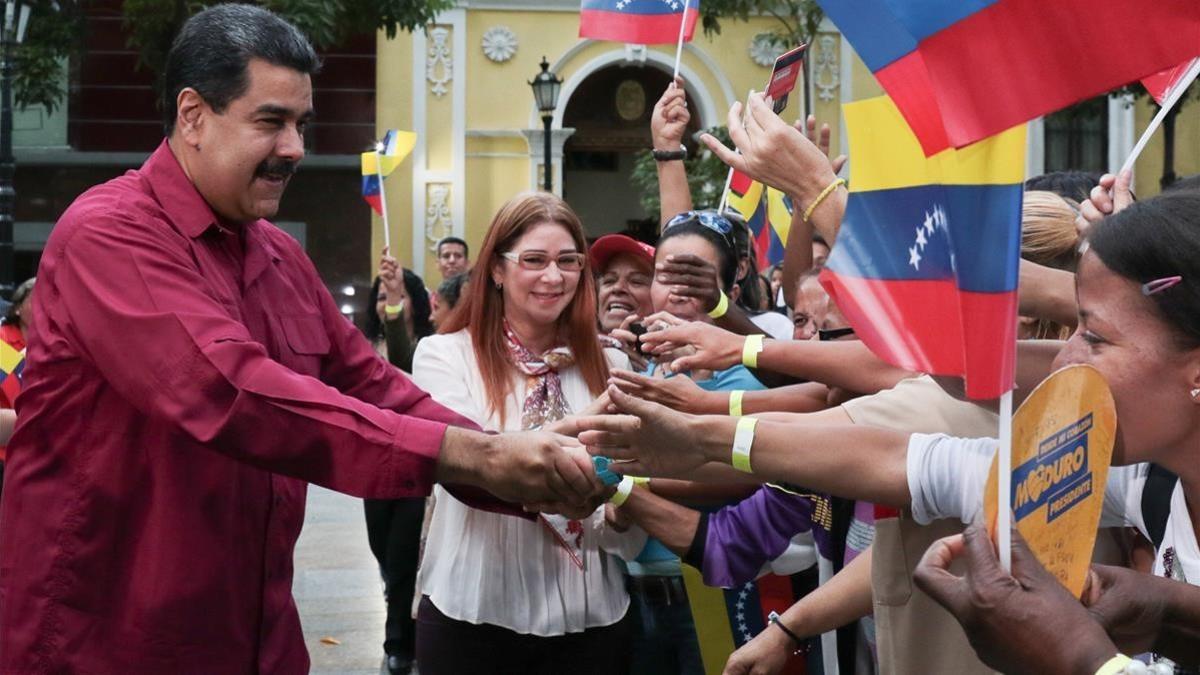 Maduro y su esposa, Cilia Flores, saludan a sus seguidores en un acto en Caracas, el 25 de enero.