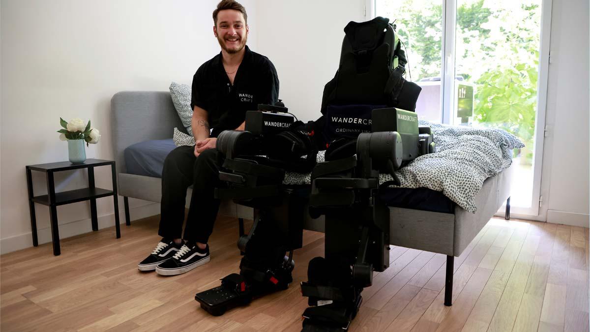 Kevin Piette posa junto a un exoesqueleto robot creado por la empresa francesa Wandercraft
