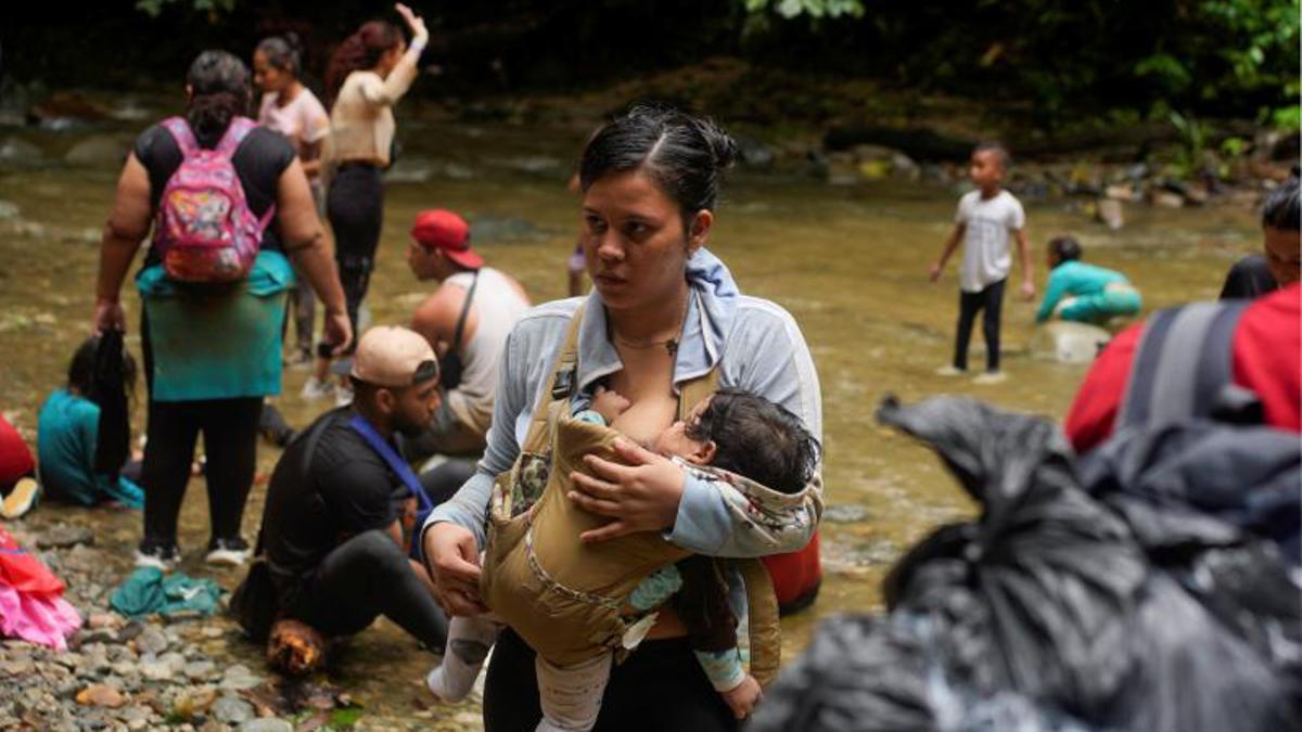 Migrantes cruzan el río Muerto en el Tapón del Darién, de viaje hacia los Estados Unidos, en Acandi, Colombia