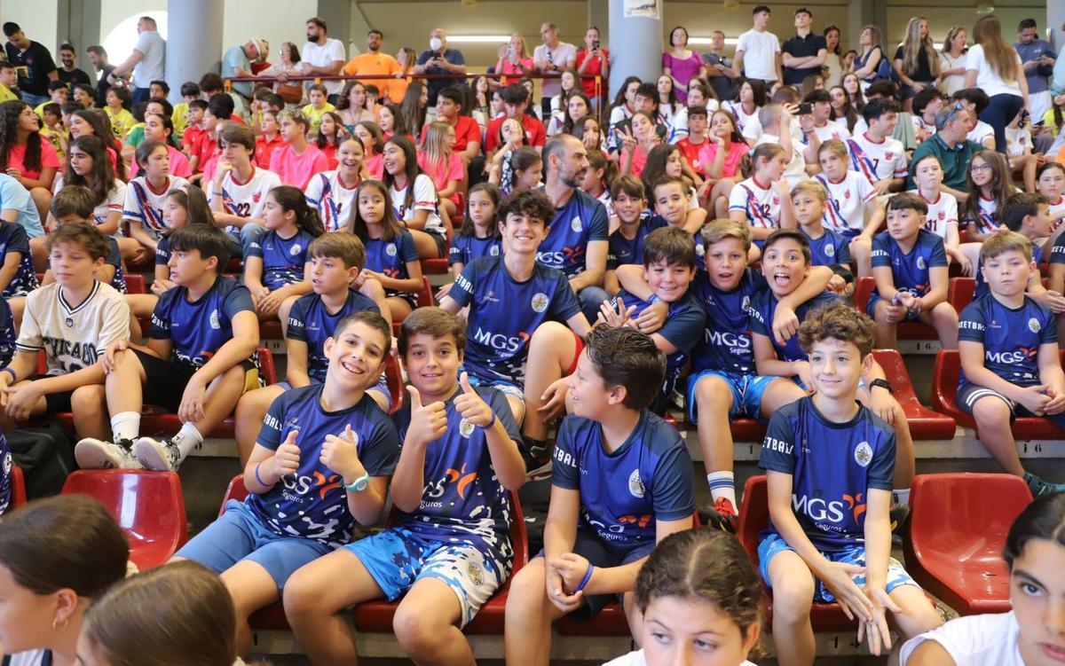 Un grupo de jóvenes deportistas siguen la entrega de premios de los Juegos Municipales.
