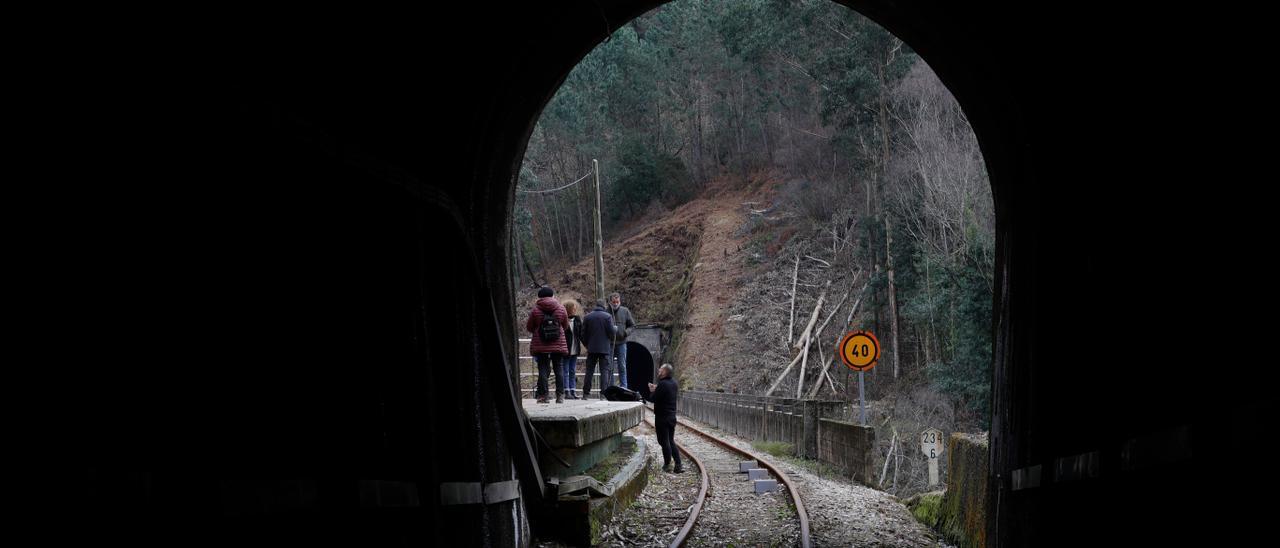 Vecinos de Santa Marina, en Cudillero, midiendo el ancho de un túnel de la antigua línea de FEVE